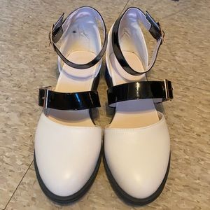Mary Jane flats, cream upper with black patent leather straps and gold buckles.